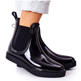 Bottes de pluie brillantes sur plate-forme cascade noire