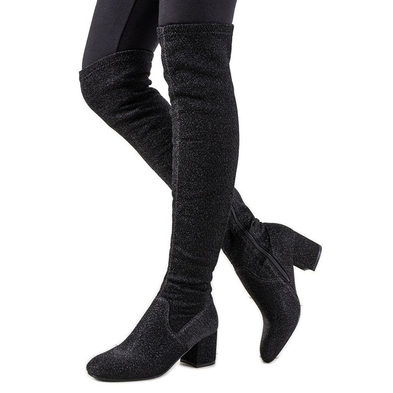 Bottes noires brillantes sur le genou d'Uta le noir argent