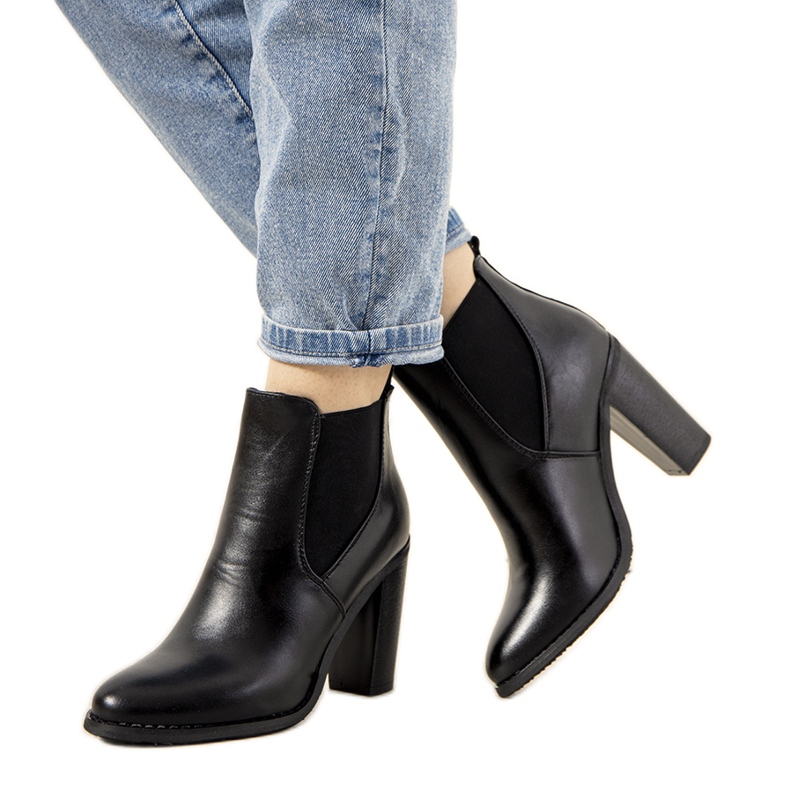 Bottes isolées noires sur le poteau de Castro le noir