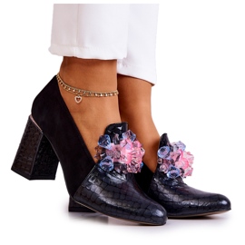 Escarpins en peau de serpent en daim sur un poteau de canapé noir