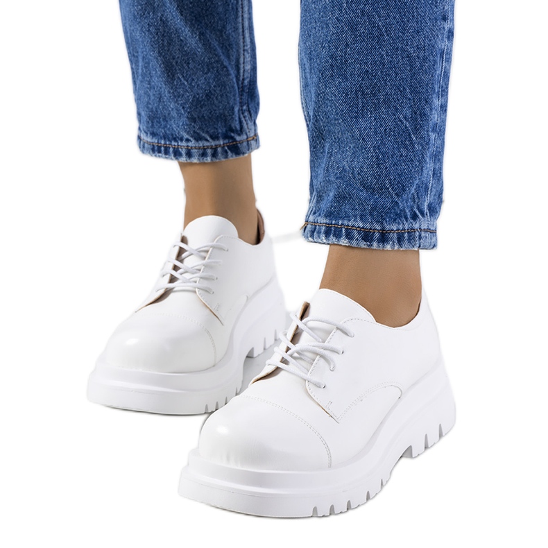 Chaussures blanches sur une semelle de tracteur de Henta Chaussures blanches sur une semelle de tracteur de Henta