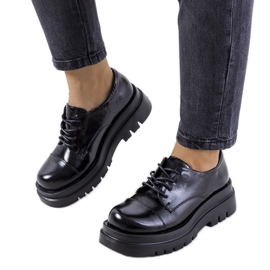 Chaussures noires sur une semelle de tracteur de Henta