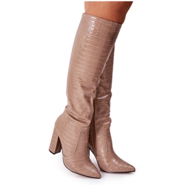 Bottes de constance beige foncé à la mode sur une barre