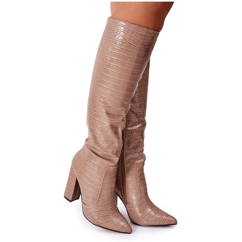 Bottes de constance beige foncé à la mode sur une barre