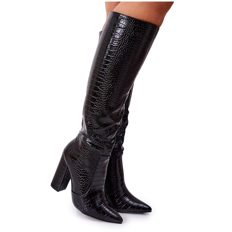 Bottes de constance noires à la mode sur un bar le noir