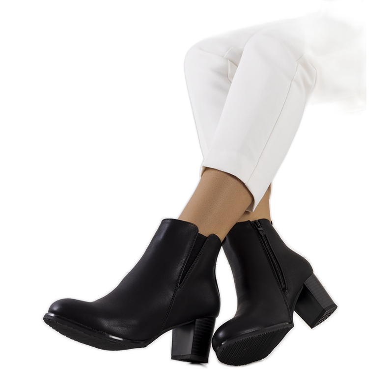 Bottes noires sur le poste du mendiant le noir Bottes noires sur le poste du mendiant le noir