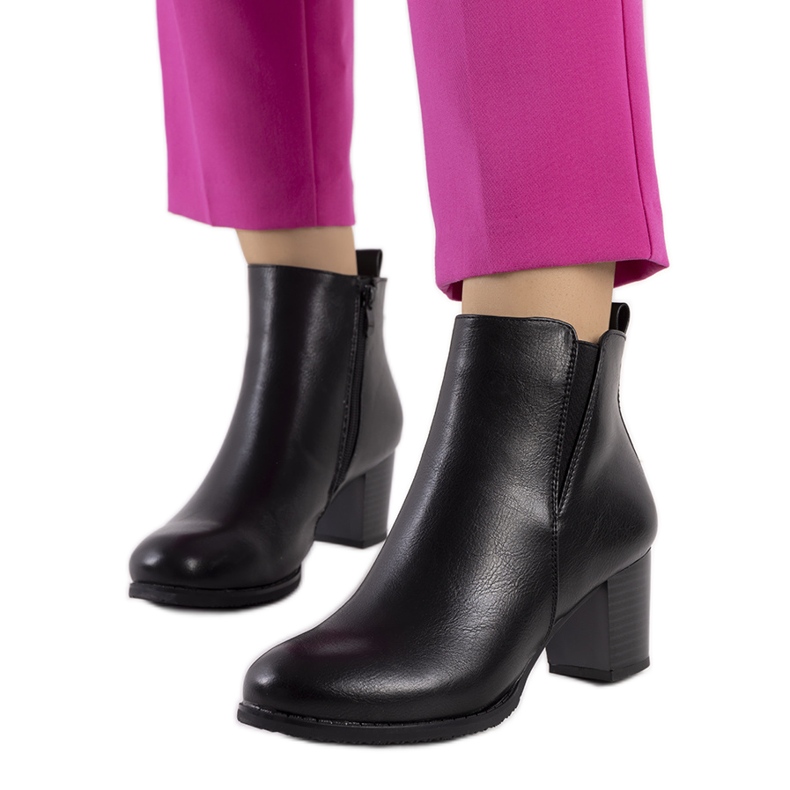 Bottes noires sur le poste du mendiant le noir