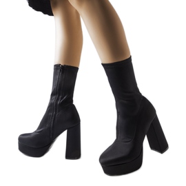 Bottes en satin noir sur un poteau massif de Glus