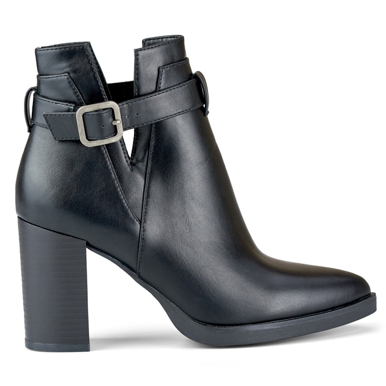 Bottes noires découpées pour femmes sur un poteau beige