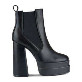 Bottes noires sur un poste élevé et une plate-forme le noir