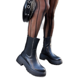 Bottes isolées noires sur la plateforme le noir Bottes isolées noires sur la plateforme le noir