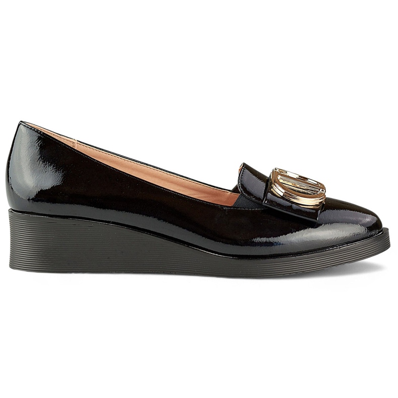 Élégantes chaussures vernies noires avec une décoration sur un coin bas le noir