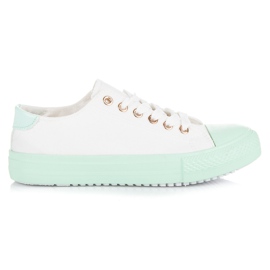 Baskets blanches sur la plate-forme verte