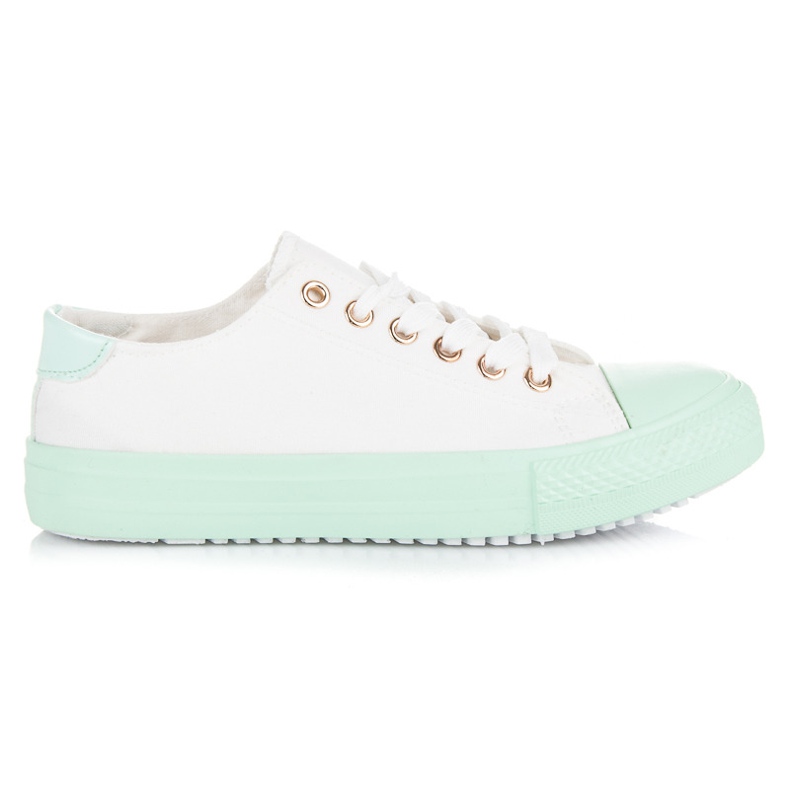 Baskets blanches sur la plate-forme verte