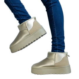 Bottes de neige basses dorées sur la plateforme