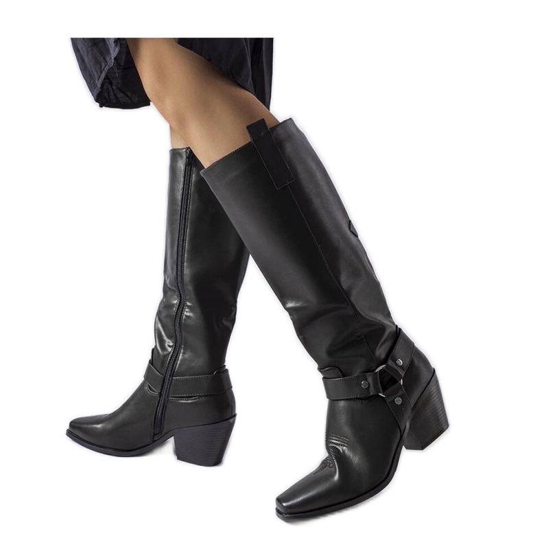 Bottes de cowboy noires sur le poteau le noir