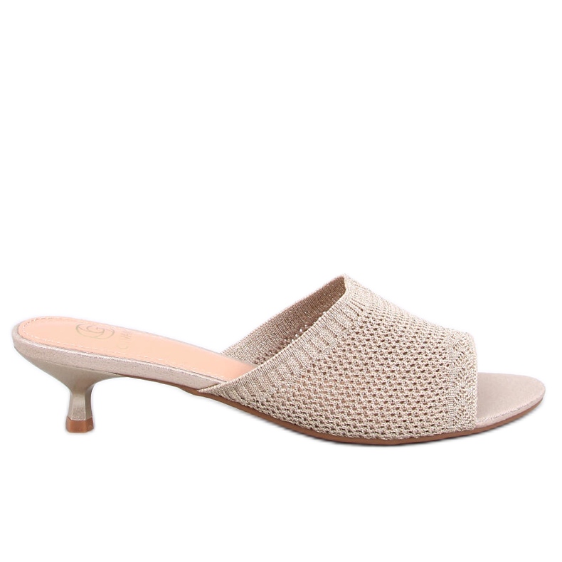 Les tongs ouverts des femmes sur l'or beige