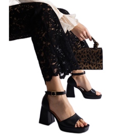 Sandales des femmes noires sur un talon massif