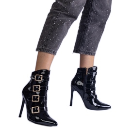 Des bottes noires verni sur une épingle avec des boucles le noir