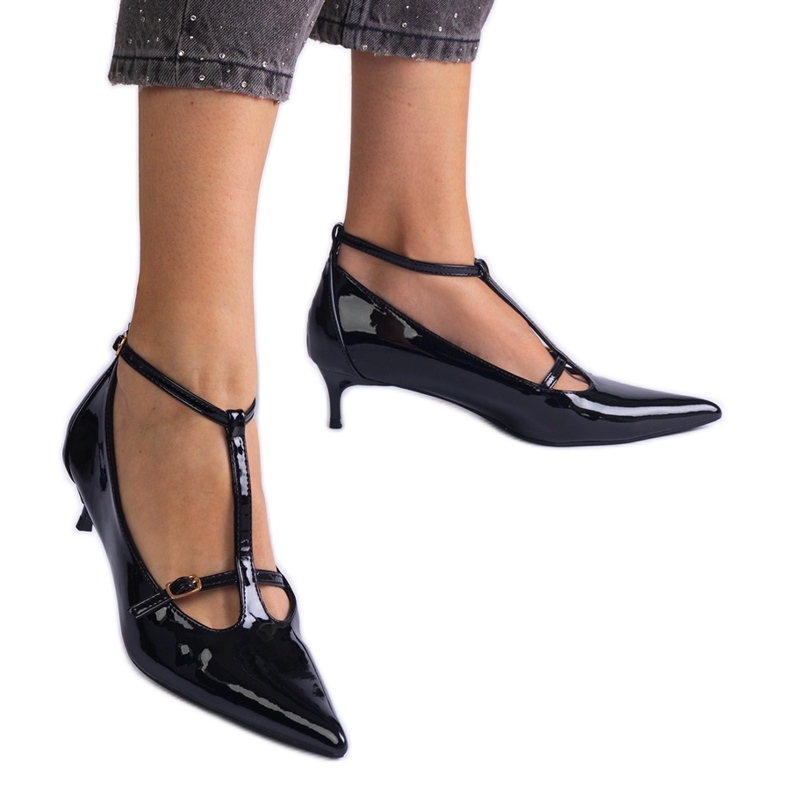 Les pompes noires ont été vernies sur un tas bas avec des boucles le noir