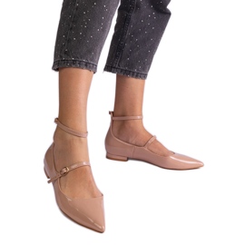 Les pompes beige verni avec des talons plats avec des boucles beiges