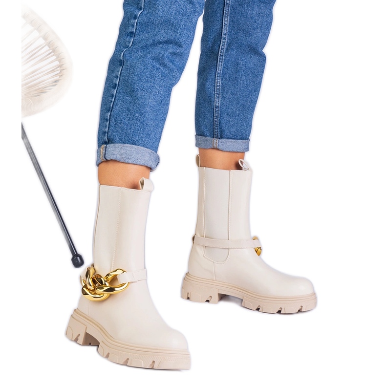 Des bottines beiges décorées d'une chaîne massive