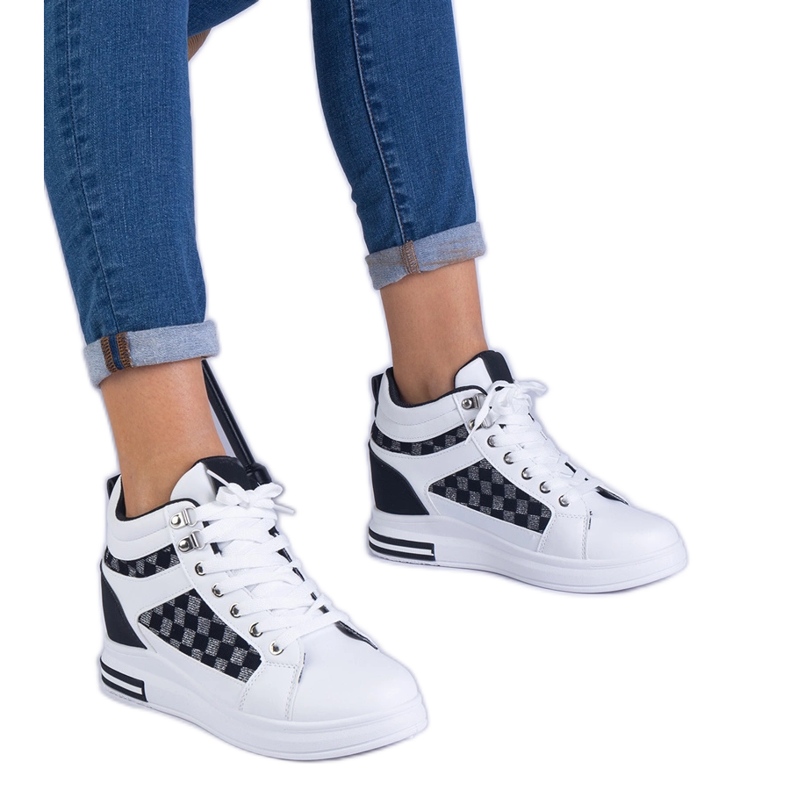 Baskets blanches pour femmes sur un coin caché le noir