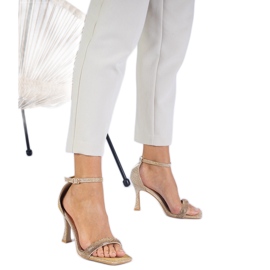 Sandales élégantes dorées sur un talon haut décoré de zircons