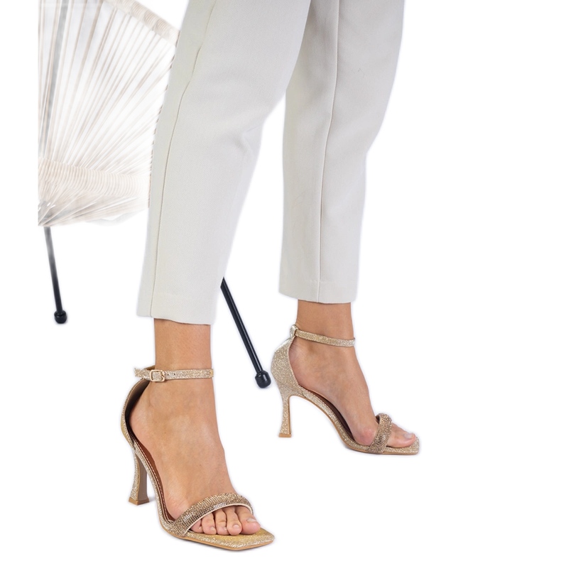 Sandales élégantes dorées sur un talon haut décoré de zircons d'or Sandales élégantes dorées sur un talon haut décoré de zircons d'or