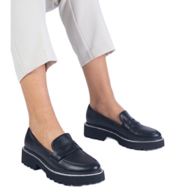 Mocassins des femmes noires sur une semelle épaisse le noir