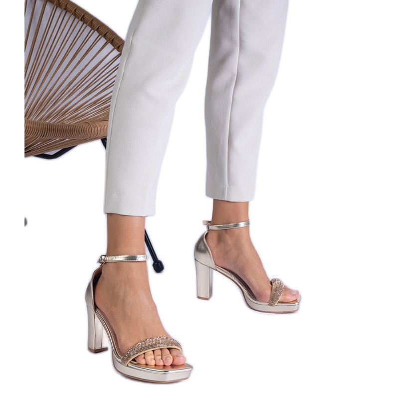 Sandales élégantes dorées sur le pilier avec des zircons d'or Sandales élégantes dorées sur le pilier avec des zircons d'or