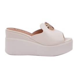 Des pantoufles sur la plate-forme et des coins avec un ornement blanc