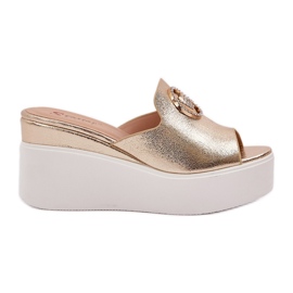 Pantoufles sur la plate-forme et coins avec un ornement doré