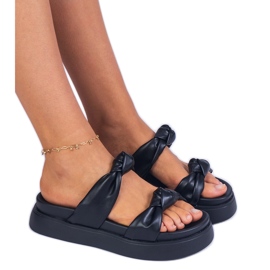 Des pantoufles noires sur la plate-forme le noir