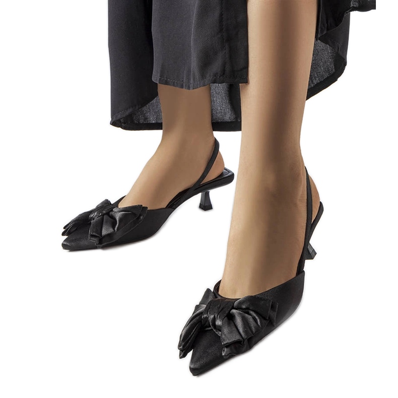 Talons hauts noirs avec un arc le noir
