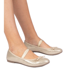 Ballerines féminines dorées avec un arc sur un groupe élastique