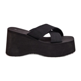 Les tongs pour femmes sur le coin et la plate-forme noirs