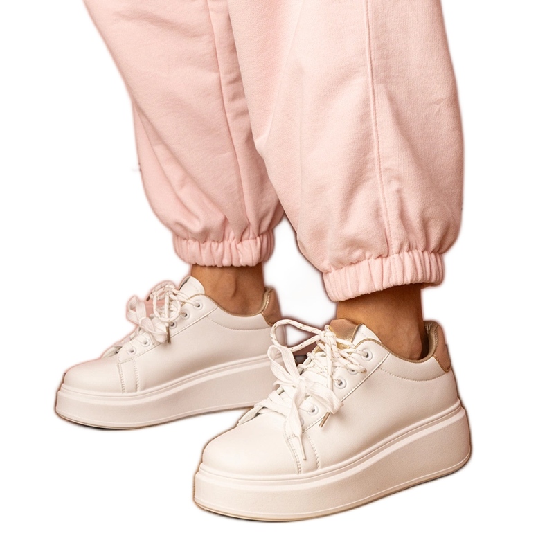 Baskets sportives blanches et or sur la plate-forme