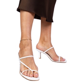 Les tongs élégants blancs sur un talon haut