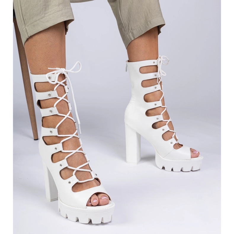 Bottes blanches sur un pilier élevé avec des découpes