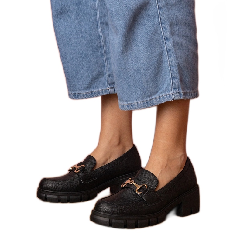 Chaussures noires sur un poteau bas avec une décoration dorée le noir