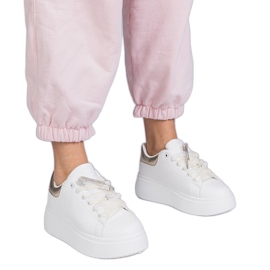 Baskets blanches avec un insert doré et une épingle en zircon
