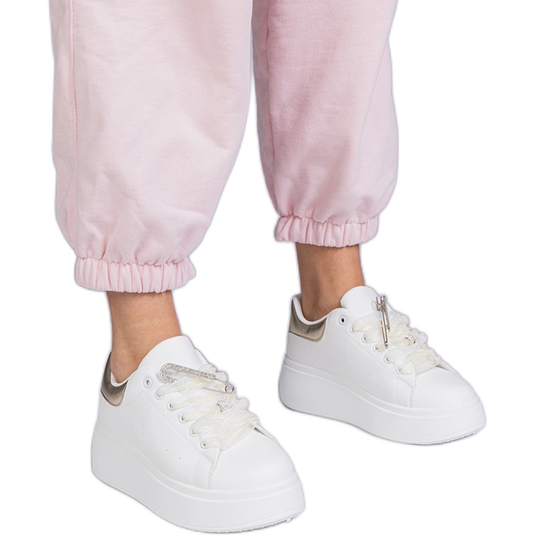 Baskets blanches avec un insert doré et une épingle en zircon
