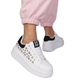 Baskets blanches avec un insert noir et des goujons