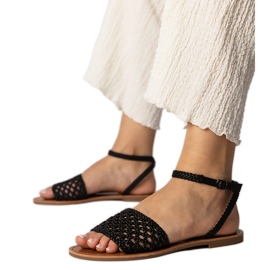 Sandales noires tissées sur une semelle plate le noir