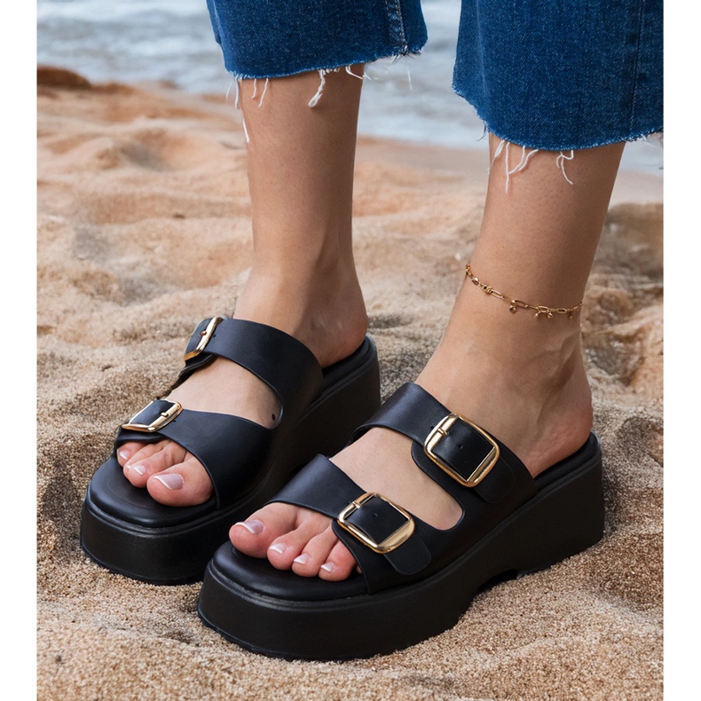 Les tongs noirs avec des pinces sur les rayures le noir