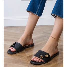 Les tongs plats noirs avec une décoration dorée le noir Les tongs plats noirs avec une décoration dorée le noir