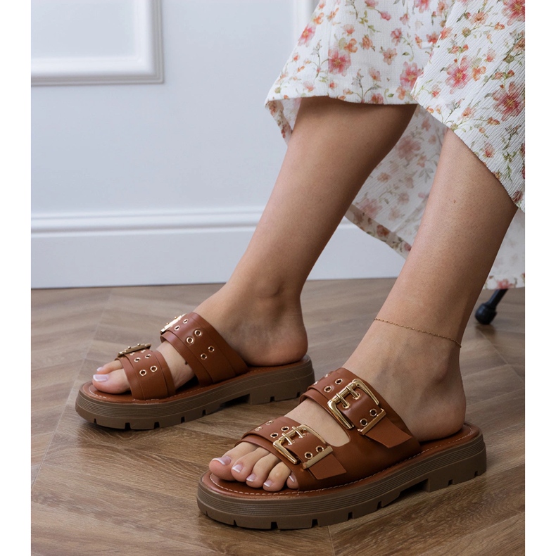 Les tongs plats bruns avec des rayures Les tongs plats bruns avec des rayures