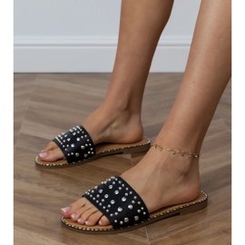 Les tongs plats noirs avec des strass sur la ceinture