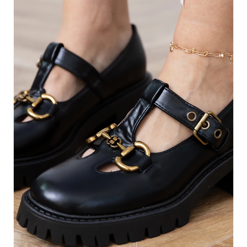 Chaussures noires sur une semelle épaisse avec une décoration dorée le noir